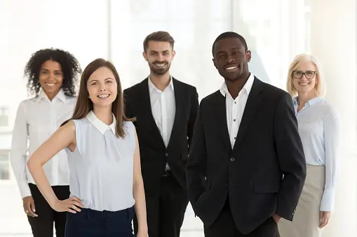 A photo of a person holding a pen and a paper, working on a real estate agent business plan for building their real estate team.