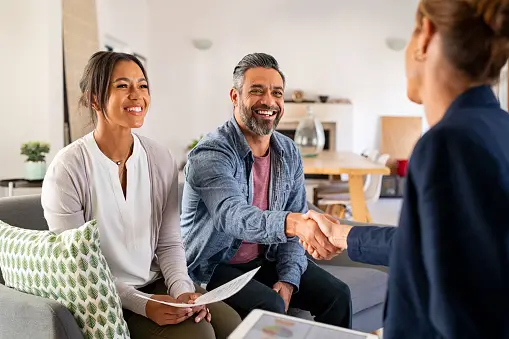 Real estate agent shaking hands with past clients