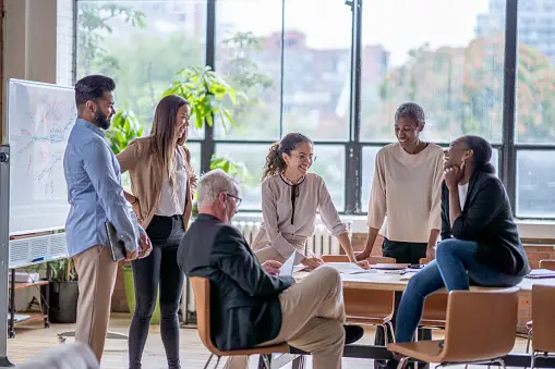 Real estate agent talking to other agents in office