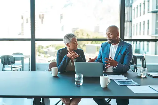 A real estate broker and agent discussing a real estate transaction in a brokerage firm