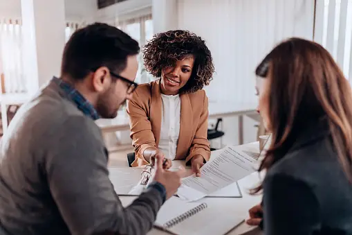 A real estate agent and a client discussing budgeting considerations for a new construction home